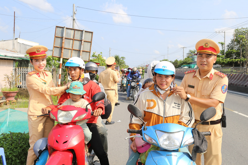 Cảnh sát giao thông Sóc Trăng tặng nón bảo hiểm và phát nước cho người dân về quê dịp nghỉ lễ