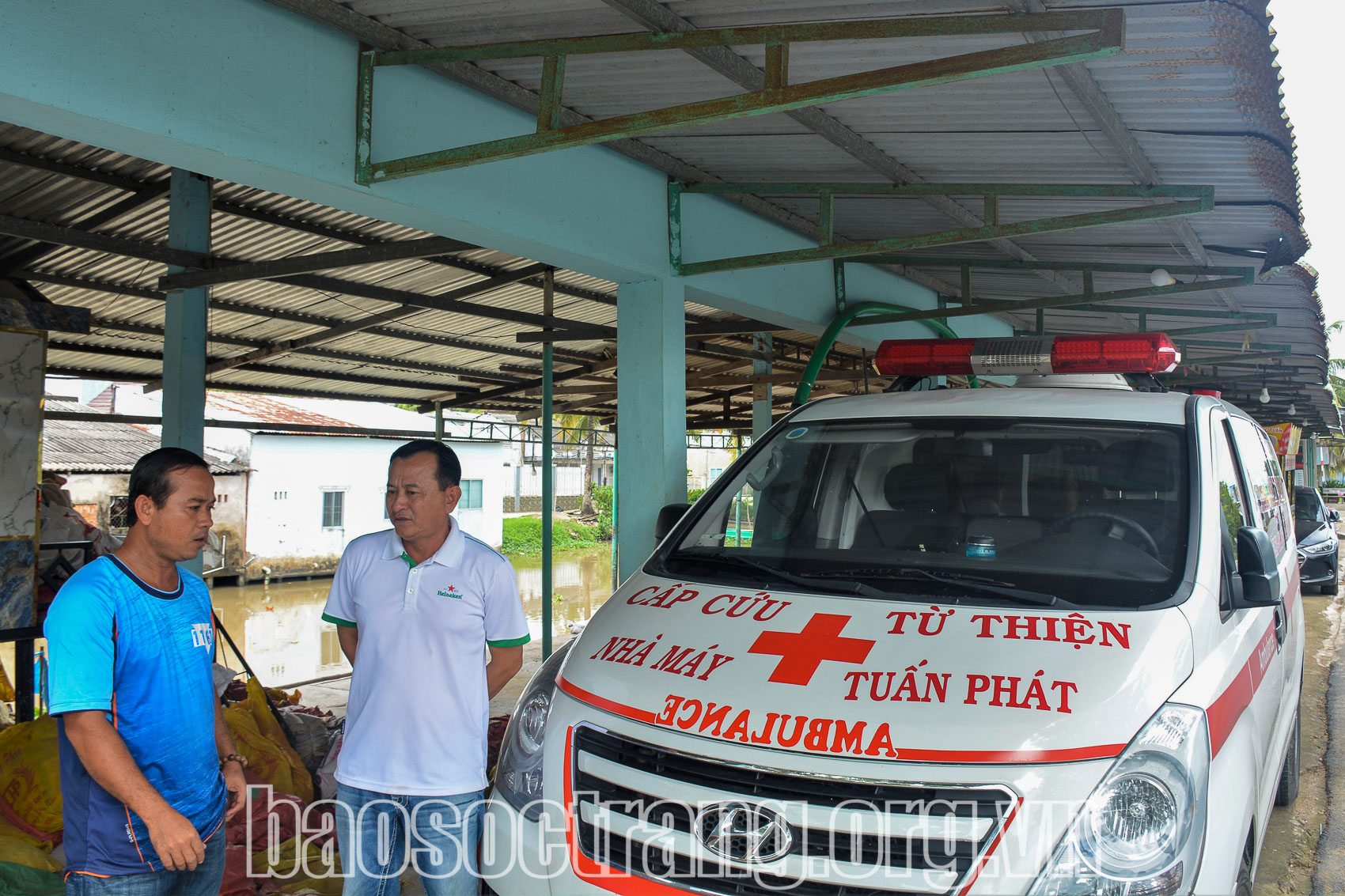 Anh Đào Hoàng Tuấn (bìa phải) hỏi thăm anh Đào Hoàng Cảnh về tình hình chở những bệnh nhân có hoàn cảnh khó khăn đi cấp cứu. Ảnh: HẢI HÀ