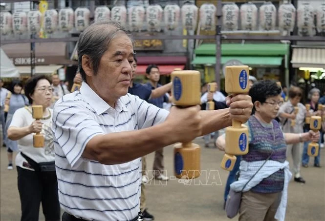 Người cao tuổi Nhật Bản tập thể dục trong công viên ở Tokyo. Ảnh: AFP/TTXVN